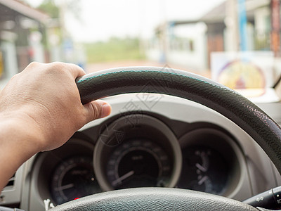 一个人的手握着汽车方向盘 在开车时驾驶汽车男性天空商务专注速度人手控制板运动内饰商业图片