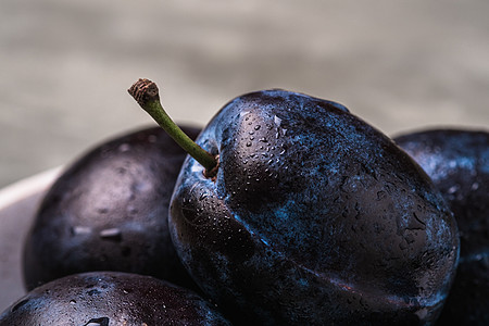 新鲜的成熟李子水果 在石块水泥上浇水营养果味宏观视角饮食团体植物石头季节紫色图片