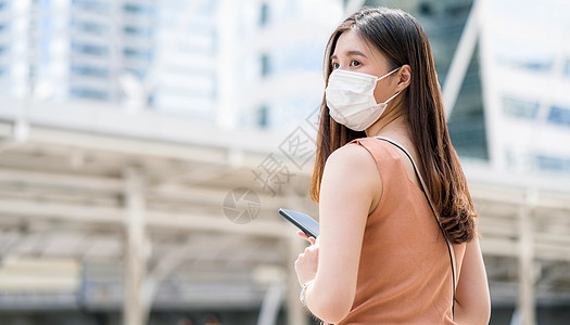 在大城市外使用智能手机的亚洲年轻女性 aa女子运输检查隔离城市旅游社交疾病通勤者结果图片