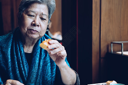 年长的亚洲老年老年妇女在餐厅吃面包祖母美食退休成人女士女性老人食物午餐图片