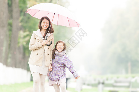 快乐的母亲和女儿在公园里走来走去女孩夹克女性妈妈家庭生活下雨孩子女士父母图片