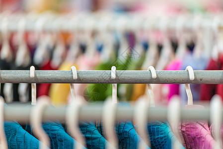 商店的衣架上挂着多彩的衣服展示织物销售纺织品贸易市场架子衣柜服装女士图片