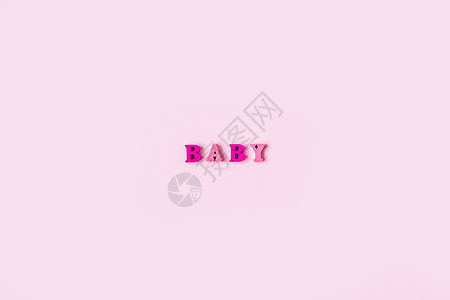 BABY 这个词是由浅粉色背景上的木制字母组成的 横幅设计 婴儿淋浴概念 最小背景的照片 装饰精美 文本位置与粉红色背景隔离孩子图片