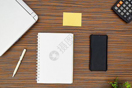 办公桌工作环境 棕色条纹斑马木设计桌面上的记事本 便签 笔杆 计算器和膝上型电脑 在 Covid19 期间在家工作时必须有物品活图片