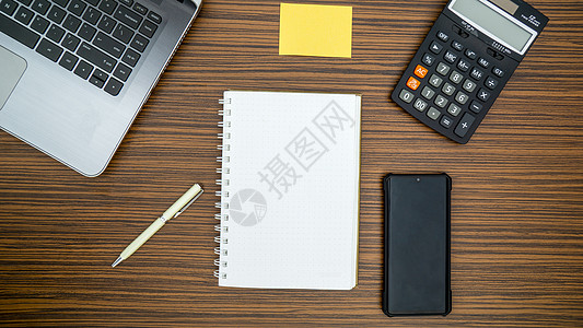 办公桌工作环境 棕色条纹斑马木设计桌面上的记事本 便签 笔杆 计算器和膝上型电脑 在 Covid19 期间在家工作时必须有物品笔图片
