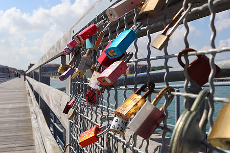 许多爱情锁挂在格玛海滨的码头上夫妻传统城市锁孔婚姻海滩挂锁雕刻栅栏旅游图片