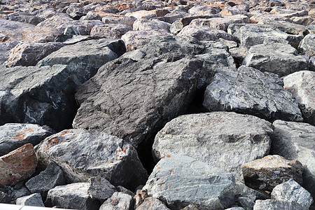 详细近视碎石和石块的碎石地灰色花岗岩棕色黑色海滩材料鹅卵石雇用岩石种子图片