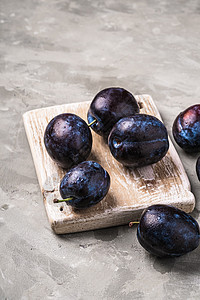 新鲜成熟的李子水果 木制切割板上有水滴食物蓝色甜点团体收成紫色木头饮食石头视角图片