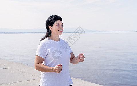 在河边附近慢跑的活跃老年女子闲暇力量运动装娱乐支撑女性享受微笑福利训练图片