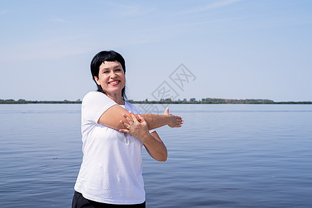 积极和快乐的老妇人 在河岸附近伸展成人跑步运动装训练运动闲暇女性活动福利锻炼图片