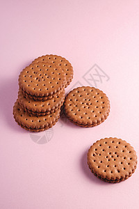 巧克力三明治饼干和粉红背景的奶油饮食甜食早餐美食粉红色芯片甜点圆圈小吃烹饪图片