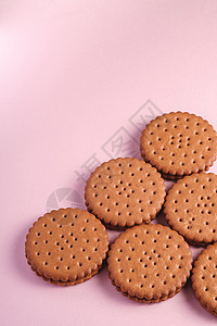 巧克力三明治饼干和粉红背景的奶油饮食甜食美食粉红色甜点早餐芯片食物店铺小吃图片