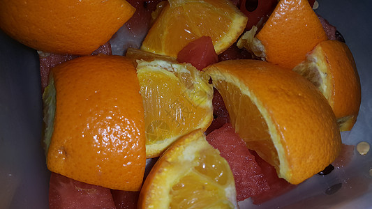 近距离观察混合水果柑橘橙子和甜红西瓜的果实切片热带果汁甜点剪裁橙子西瓜片种子食物饮食小吃图片
