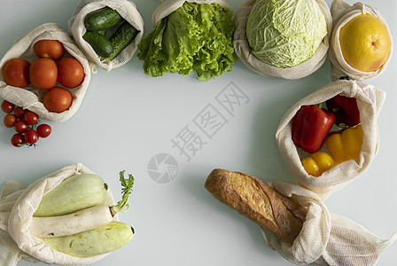 桌上可重复使用的生态棉袋中的蔬菜 水果 零浪费购物理念 无塑料物品 多次使用 再利用 回收 生态友好的帆布杂货袋 配有西红柿 胡图片