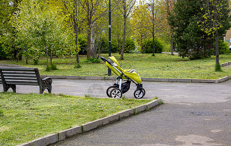 公园中央矗立着一辆绿色婴儿车 带孩子旅行 运送孩子 孩子走路的概念婴儿运输儿童图片