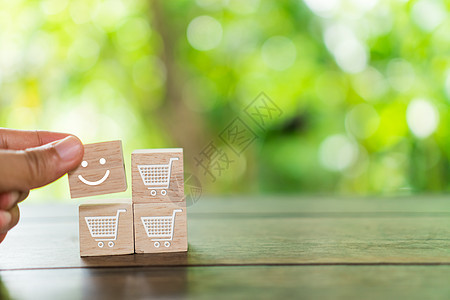 木立方体上的笑脸和购物车图标 购物满意度概念时乐观的人或人的内心感受和服务评级审查快乐童年顾客质量情感战略用户产品喜悦背景图片
