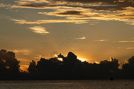 太阳笼罩在大海云后 日出射向大海图片