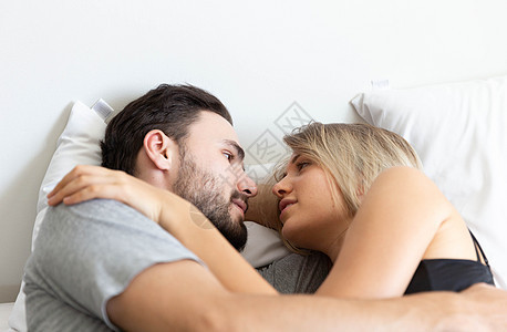 可爱的小情侣拥抱和睡在床上男人女孩床单金发就寝男性枕头说谎家庭时间图片