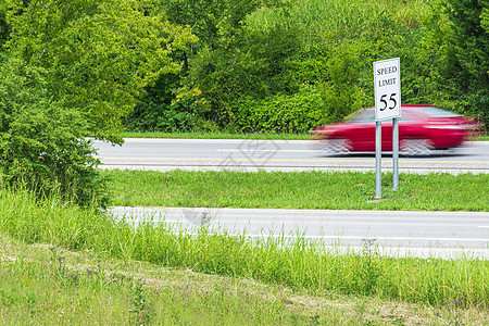 快速超速超过速度限制标志的红色赛车图片
