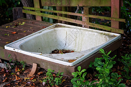 旧浴缸被弃在一个花园里图片