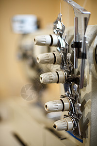 缝纫机超锁 工作场所裁缝工 打工业的特写细节织物制造业女裁缝服装剪裁机器纺织品家庭工艺工厂图片