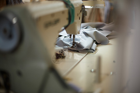 特写缝纫机 灯光照明 工作场所裁缝 缝纫业服装生产棉布物品宏观工艺商业工作机器纺织品图片