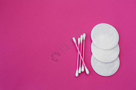 粉红色棉芽的顶视图 白色头和白色圆形棉盘放在粉红色背景上图片