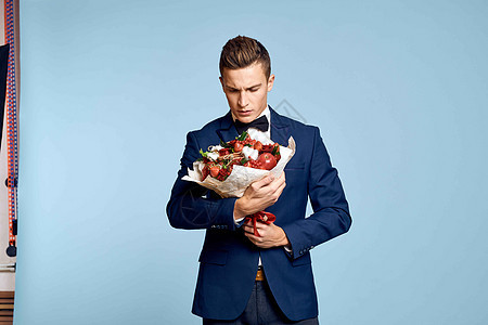 浪漫男人 有一束花朵和领结 在蓝色背景的风景下庆典玫瑰礼物成人周年人士生日花束商务展示图片