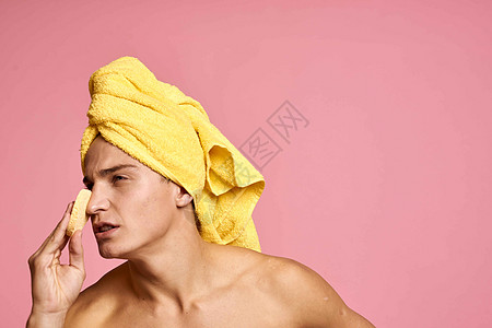 头上戴毛巾的男子和手掌上印有黄色海绵的人 将脸皮清洗干净微笑皮肤卫生浴室温泉护理头发身体男生剃须图片