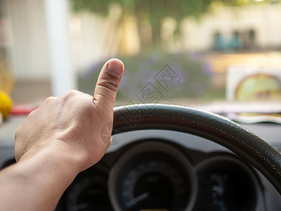 一个人的手握着汽车方向盘 在开车时驾驶汽车专注司机挡风玻璃车轮旅行街道速度交通内饰商业图片