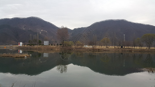 可以看到大山上河流水和绿树的美丽景象蓝色丘陵场景树木环境阳光晴天太阳季节风景图片