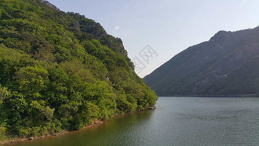 可以看到大山上河流水和绿树的美丽景象阳光农村树木草地太阳地平线晴天丘陵风景天空图片