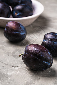 新鲜成熟的李子水果 木碗水滴宏观紫色收成团体食物木头盘子视角蓝色饮食图片