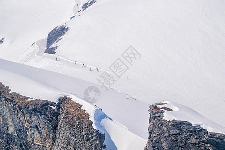 滑雪者独自带着头盔在通往马特霍的滑雪坡上滑雪女性高山山脉粉末冒险女士晴天兜帽蓝色活动图片