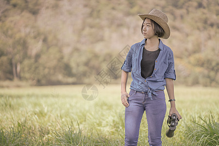 妇女戴帽子 在草地佩戴望远镜监视天空野生动物间谍女孩女性森林绿色双目冒险图片