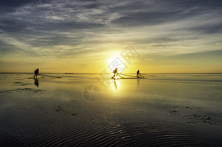 黑影渔民在清晨日落海洋海滩橙子蓝色反射天空渔夫旅行钓鱼图片