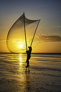 黑影渔民在清晨太阳旅行橙子海滩天空日落渔夫蓝色文化海洋图片