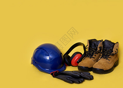 黄色背景的个人防护设备黄底个人防护设备装备衣服蕾丝安全工作安全帽头盔商业靴子皮革图片