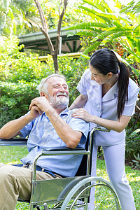 护士照顾一名年长的男性 在他花园里坐在轮椅上男人退休女性讲话病人服务照顾者医生残障快乐图片