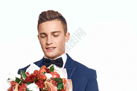 一个穿着经典西装的优雅男子 领领结领带 手里握着一束花束男性男人商务花朵婚礼套装礼物周年生日庆典图片