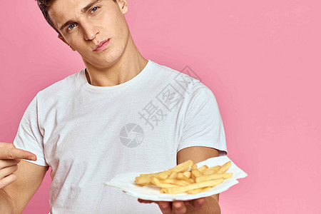 粉红背景卡路里纸盒里有薯条的男人 快速食品肖像粉红色背景胡子脂肪男生肥胖饮食工人男性餐厅芝士成人图片