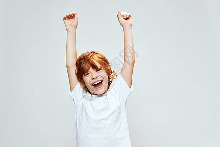 快乐的红头发男孩举起双手 头顶满满脸笑容图片