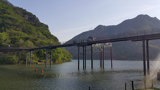 可以看到大山上河流水和绿树的美丽景象牧场农村场景树木天空丘陵环境蓝色晴天草地图片