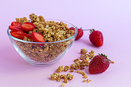 草莓片在粉红色背景上 蔬菜菜盘 健康早餐的自制颗粒子勺子运动浆果巧克力活力碳水青年化合物杏仁美味图片