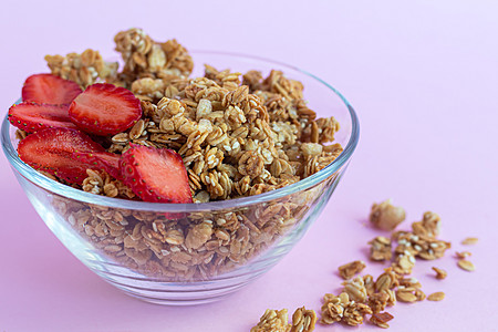 草莓片在粉红色背景上 蔬菜菜盘 健康早餐的自制颗粒子颗粒剂碳水浆果饮食巧克力粮食亮度勺子化合物葡萄干图片