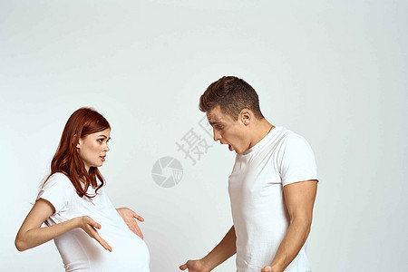 一个孕妇和一个年轻人在浅色背景下等待婴儿的情绪家庭爱夫妻母亲母性孩子父亲父母男性腹部幸福生活图片