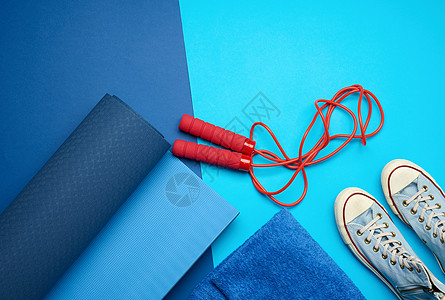 扭曲的蓝色垫子 一双蓝色运动鞋 和红色跳板罗图片