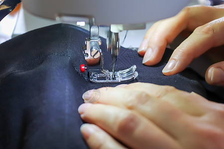缝纫裁剪缝纫概念 女性手在现代缝纫机上工作工人工艺材料纺织品职业针女机器裁缝接缝工具背景