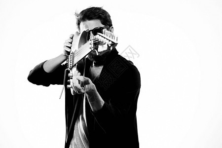 一个有吉他情调的男人 音乐游戏表演 皮夹克外衣太阳镜 光背景吉他星星娱乐音乐家音乐会金属青年乐趣低音演员图片