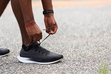 黑人男子站着 试图穿鞋带跑鞋运动鞋训练跑步活动赛跑者衬衫运动黑色体育场鞋类图片